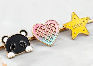 Colorful enamel pins featuring a panda, a pink and blue heart, and a yellow star with "LOVE" written inside, perfect for personalized promotional products and custom accessories.